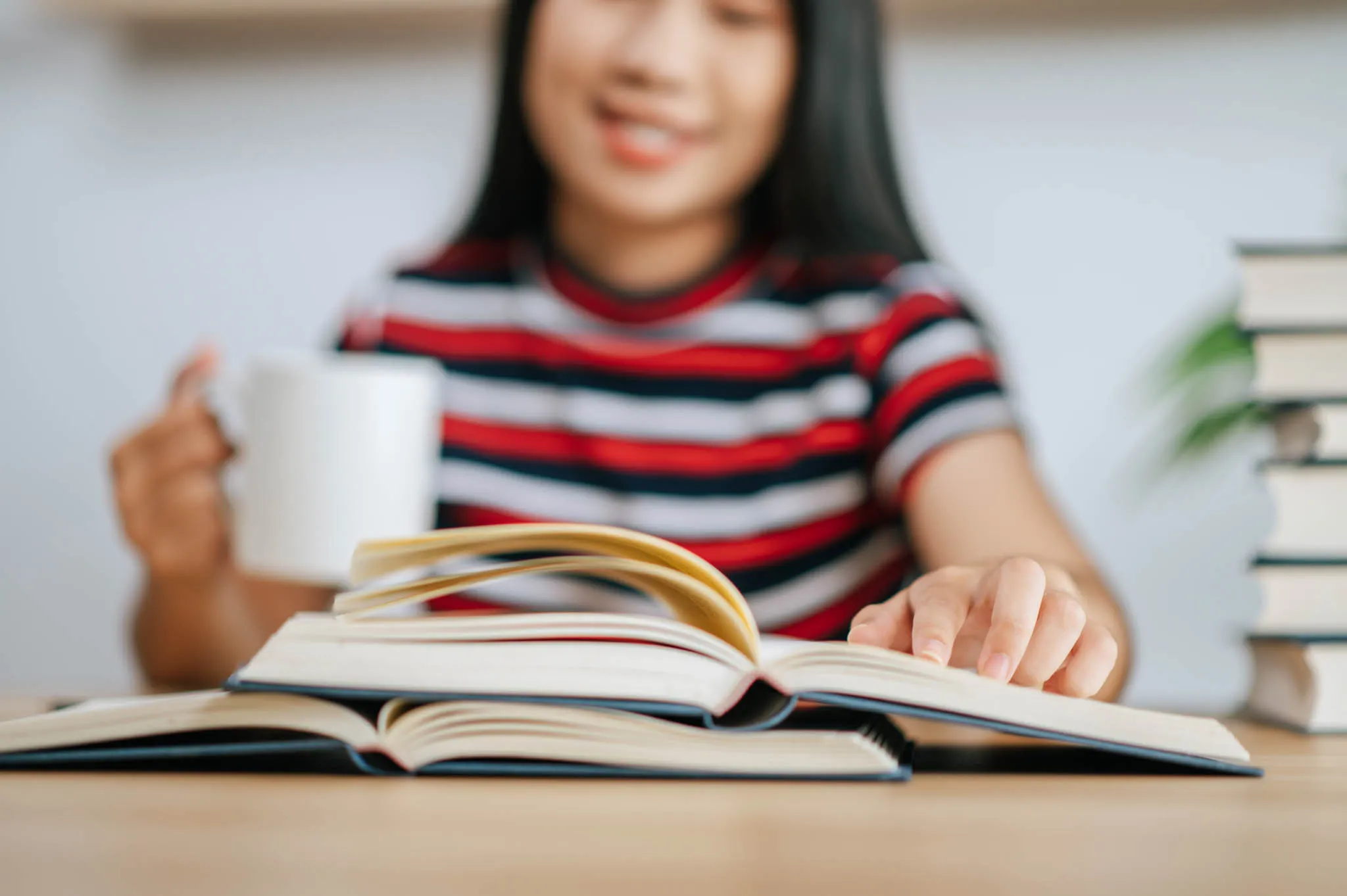 Estudiante leyendo varios libros como parte del proceso de aprendizaje y comprensión profunda.