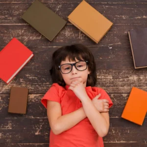 Niño rodeado de libros reflexiona sobre la lectura y el valor de comprender antes de transformar.